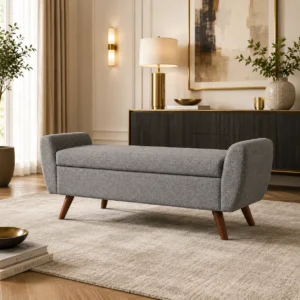 Grey upholstered storage bench with padded seat and tapered wooden legs for modern interiors