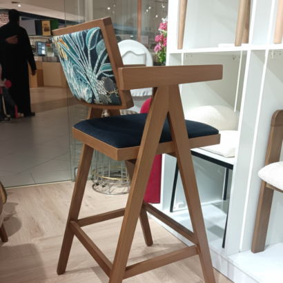 Solid wood bar stool with integrated armrests.