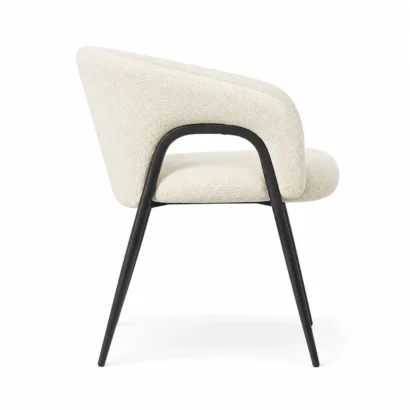 Side view of cream bouclé dining chair with curved backrest and black metal frame