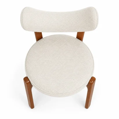 Top view of a cream fabric dining chair showing the curved backrest and padded seat