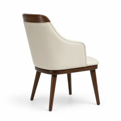 Cream faux leather dining chair shown from a side angle with walnut wood detailing