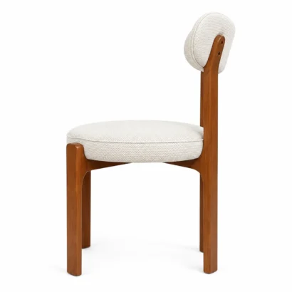 3/4 view of a modern cream upholstered dining chair with wooden legs