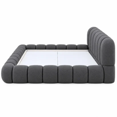 Side view of a charcoal upholstered platform bed showing its padded side rails and headboard.
