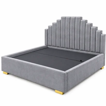 Angled view of grey upholstered bed frame with stepped headboard and gold feet